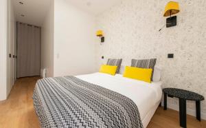 a bedroom with a large bed with yellow pillows at Andy in Paris