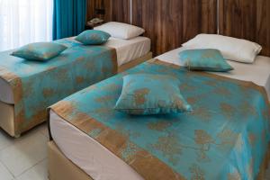 Zwei Betten in einem Zimmer mit blauer und brauner Bettwäsche in der Unterkunft Elijah Hotel in Kemer