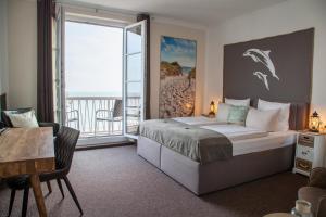 una camera da letto con un letto grande e un balcone di AKZENT Strandhotels Seestern, Delphin & Lachs a Wilhelmshaven