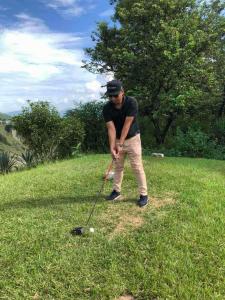 a man hitting a golf ball with a club at Le Glamour Luxury Resort & Wellness Spa Pvt Ltd in Pokhara