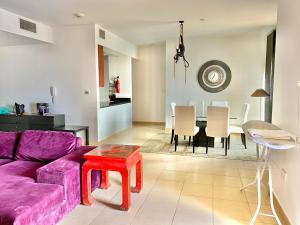 a living room with a purple couch and a table at Amazing and spacious apartment in JBR in Dubai