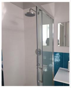 una ducha con puerta de cristal en un baño en elefante appartamenti, en Pescara 13 fotos más
