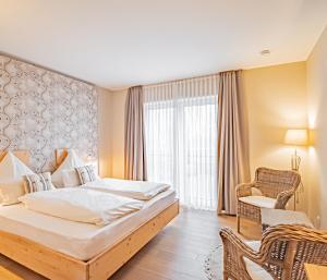 una camera d'albergo con letto e sedia di Johannishof Wein-Café & Gästehaus a Mesenich