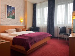 A bed or beds in a room at Hotel Stadt Hamburg am Fluss Saarbrücken