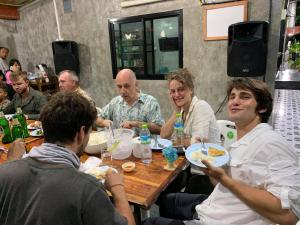 a group of people sitting at a table eating food at Green House Resort Praduyuen in Uthai Thani