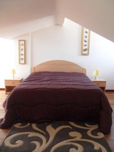 a bedroom with a bed with a purple comforter at Porta Del Sole in Manfredonia