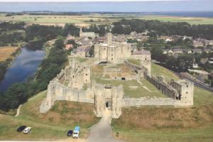 an aerial view of a castle with cars parked at The Coquet Apartment - short stroll to Warkworth Castle and Hermitage in Warkworth