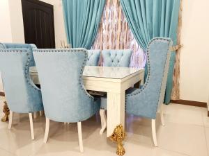 a dining room with blue chairs and a table at Royal Villa F-10/2 in Islamabad
