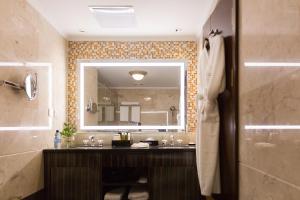 a bathroom with a sink and a mirror at Golden Tulip Addis Ababa in Addis Ababa