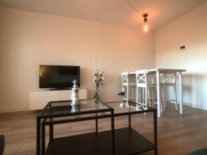 un soggiorno con TV, tavolo e tavolo di Residence Deurloo 53-08 a Cadzand