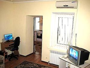 a living room with a television and a desk and a window at 2 ком кв Соборная-Макарова-МАКДОНАЛЬДС 3 кровати Wi-Fi 1этаж отдельный вход in Mykolaiv