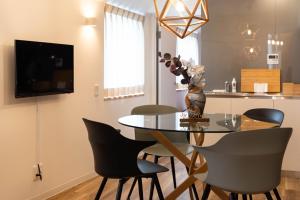 a dining room with a glass table and chairs at Alla Scuderia Bijou Suites in Osaka