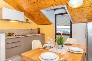 a kitchen and dining room with a wooden ceiling at Apartments Alida in Poreč