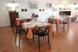 a dining room with tables and chairs with orange napkins at AGRITURISMO CASA RICOTTA in Metaponto +4 photos