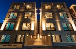 a building with lights on the front at night at Luana Shibuya in Tokyo