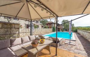 a patio with a table and an umbrella next to a pool at Villa Kluni by Rent Istria in Momjan