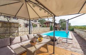 a patio with a table and an umbrella next to a pool at Villa Kluni in Momjan