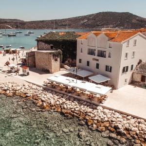 an aerial view of a building with a restaurant next to the water at Guest House Adria in Primošten