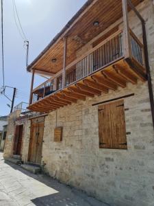 un antiguo edificio de ladrillo con un balcón de madera. en Kassandras place in Omodos village, en Omodos