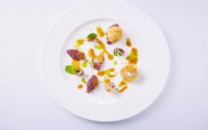 a white plate with food on a white background at Baglioni Resort Sardinia - The Leading Hotels of the World in San Teodoro