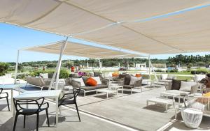 a patio area with chairs, tables and umbrellas at Baglioni Resort Sardinia - The Leading Hotels of the World in San Teodoro
