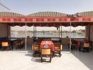 a patio area with tables, chairs and umbrellas at Nile Castle in Luxor