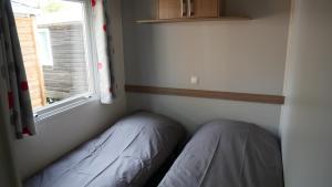 Kleines Zimmer mit einem Bett und einem Fenster in der Unterkunft Mobil-Home Cosy - Matelas qualité hôtel in Passy