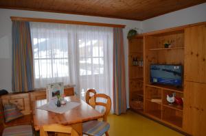 a living room with a table and a tv and a window at Apartment Mauser-Mühltaler in Mauterndorf