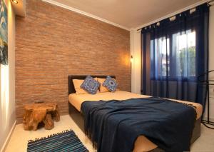 sypialnia z łóżkiem i ścianą z cegły w obiekcie Porto Thea Alexandra Shared Pool Villa, Afytos w Áfitos +33 zdjęcia