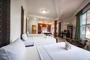 a hotel room with two beds and a living room at Angkor International Hotel in Phnom Penh