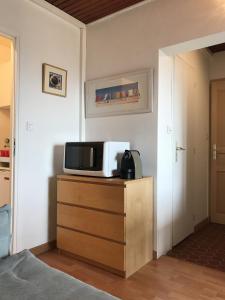 eine Mikrowelle auf einer Kommode in einem Zimmer in der Unterkunft Résidence Les Pierrettes in Saint-Gilles-Croix-de-Vie