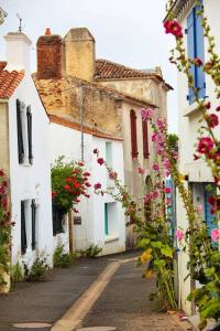 eine Reihe weißer Häuser mit rosa Blumen auf einer Straße in der Unterkunft Résidence Les Pierrettes in Saint-Gilles-Croix-de-Vie