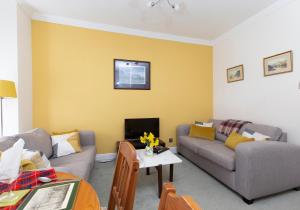 a living room with two couches and a table at Blair St Scott apt Old Town in Edinburgh