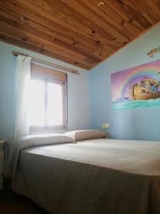 1 dormitorio con 1 cama con una pintura de arco iris en la pared en Casa Rural Los Pineros, en Montán