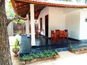 a house with a table and chairs in it at Sulashika Beach House in Kandakuli