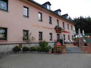 a large pink building with a sign in front of it at Hotel und Restaurant Golden Village in Riesa