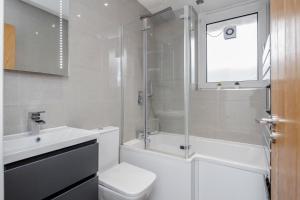 a bathroom with a toilet and a sink and a shower at Luxury Chic Apartment near Canary Wharf, Excel, O2 & Stratford in London +25 photos