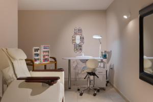 a therapy room with a chair and a table at Maritim Antonine Hotel & Spa in Mellieħa