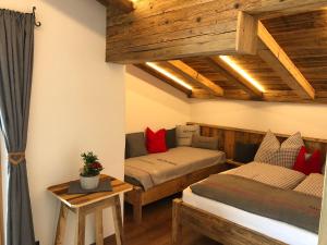 two beds in a room with wooden ceilings at Haus Tannenheim in Filzmoos
