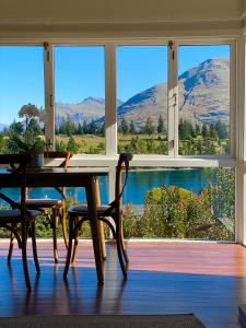 a dining room with a table and chairs and a large window at Stay of Queenstown in Queenstown