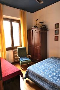 a bedroom with a bed and a chair and a window at La casa di Roberto in Rome