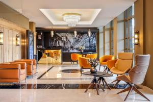 - un hall avec des chaises orange et une table dans l'établissement Hotel des Vosges BW Premier Collection, à Strasbourg
