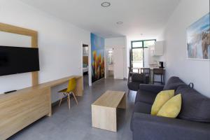 a living room with a couch and a flat screen tv at Alsol Walhalla in Playa del Ingles