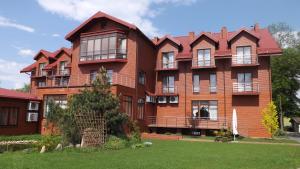 a large red brick building with a green yard at Hotel Pod Dębami in Terespol