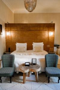 una camera da letto con un letto con due sedie e un tavolo di Riad O a Marrakech