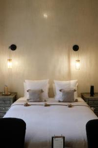 una camera da letto con un grande letto con lenzuola e cuscini bianchi di Riad O a Marrakech