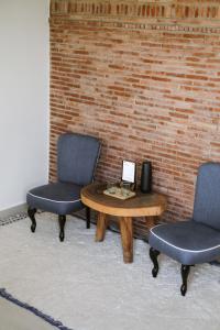 due sedie e un tavolo di fronte a un muro di mattoni di Riad O a Marrakech