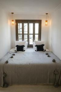 a bedroom with a large bed with two pillows at Riad O in Marrakesh