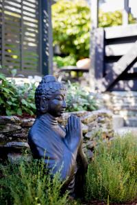 Una statua di una donna seduta in un giardino di Stay of Queenstown a Queenstown