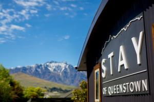 a sign for a train station with mountains in the background at Stay of Queenstown in Queenstown